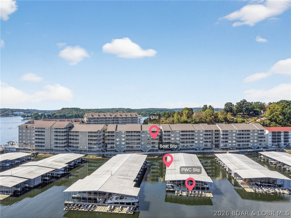 Lakefront living at its best! This 3BR/2BA, 1,400 sq ft condo in a gated community offers everything you need to enjoy the Lake of the Ozarks lifestyle. The open-concept layout features a spacious kitchen with tile flooring and breakfast bar, flowing into a bright living room with access to a screened-in porch overlooking the water. Perfect for entertaining or relaxing! The primary suite offers lake views and a private bath. Included is a 12x32 boat slip and PWC slip, making lake days effortless. Community amenities include a pool, well-kept grounds, and easy access to dining, shopping, and entertainment by land and water. With panoramic lake views, modern comforts, and secure entry, this condo is ideal for full-time living, or a vacation retreat. Start making memories at the Lake today!