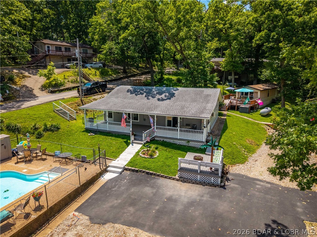 Perfectly located in the heart of Osage Beach, this beautifully updated 3-bedroom, 2-bath lake home offers the ideal combination of comfort, convenience, and lake lifestyle. Remodeled just three years ago, this turnkey property features an open-concept layout, a stylish remodeled kitchen, porcelain wood flooring, a split-bedroom design, newer appliances (approximately 2 years old), new windows, new siding, and a 2019 roof. Step outside to the oversized covered deck, perfect for entertaining, or relax on the front patio with lake views just 100 feet from the water. The flat yard, abundant parking, and 12'x20' storage shed add even more functionality. A 10'x24' boat slip (#4) with a 10,000 lb. lift is included, with the ability to add a PWC slip. Enjoy a quiet, golf cart-friendly community with no nightly rentals, city sewer, and an affordable HOA of just $1,500 per year. The community pool, playground, and boat trailer parking are only steps away. Whether you want a peaceful cruise through the nearby state park or easy access to the Lake's most popular waterfront restaurants, bars, and annual boat races just outside the cove, this location truly offers the best of both worlds.
