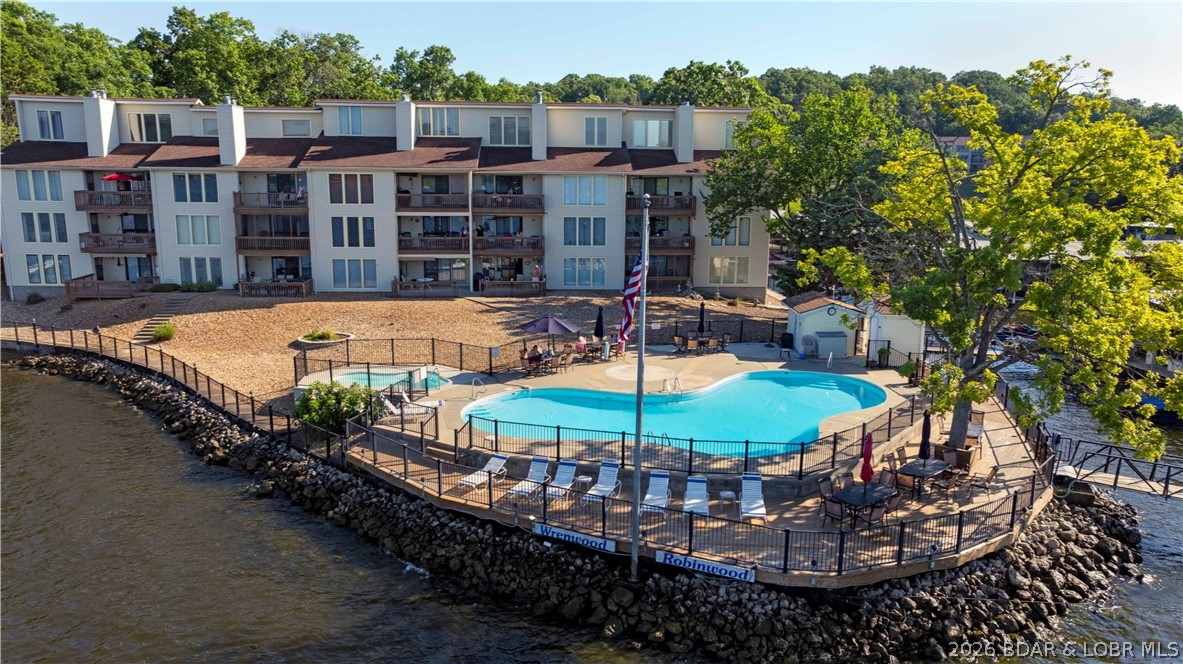 At Wrenwood Condominiums, tucked along the quieter end of Horseshoe Bend, this furnished 2-bedroom, 2-bath top-floor end unit offers a relaxing Lake Ozark retreat with investment potential. Vaulted ceilings and an open living, dining, and kitchen area create an airy, welcoming feel, while the covered deck is the perfect place to unwind with peaceful cove protection and main channel views. Rentals are allowed, including nightly, weekly, monthly, and long-term options. Owners also enjoy community amenities like 2 pools, 2 hot tubs, clubhouse, tennis courts, playground, and a covered dock with an included 10x24 slip and 8,000 lb lift.