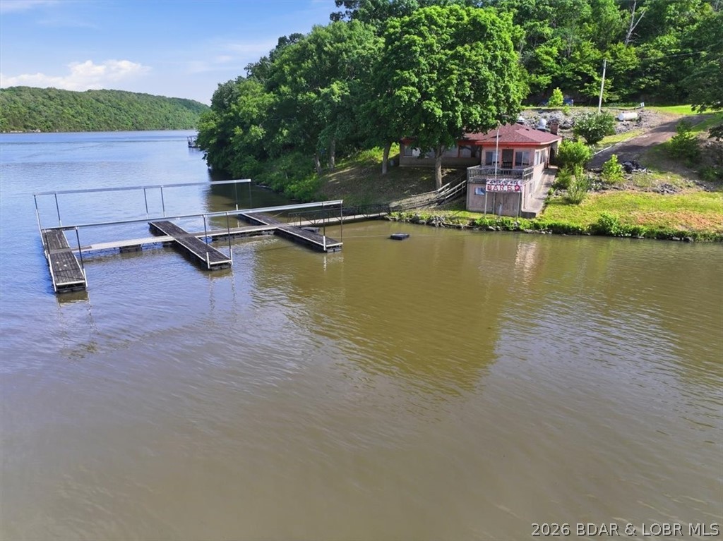 Premium Commercial Waterfront Opportunity at the 66 MM. Seize a rare opportunity to own a legendary piece of Lake of the Ozarks history. Situated at the 66 mile marker, this iconic waterfront property operated as a highly successful, deeply rooted local landmark from 1988 to 2022. Now, it stands ready for a visionary NEW owner to write it next chapter. Premier Accessibility and Infrastructure includes dual access, reachable via private road or water with ample places to park your vehicle or boat. Commercial dock with room to expand the 8 plus boat slips. Complete commercial kitchen with stainless steel prep stations and custom built 4-door, 3 tier pit to carry on the rich local barbecue tradition. Turn-key layout with a shower, private bathroom and public restroom facilities. Whether you choose to revive the celebrated culinary legacy or transform the versatile structure into an entirely new custom commercial venture, this property provides the perfect foundation for your dreams. Turn Your Vision into reality and call to schedule your private tour.