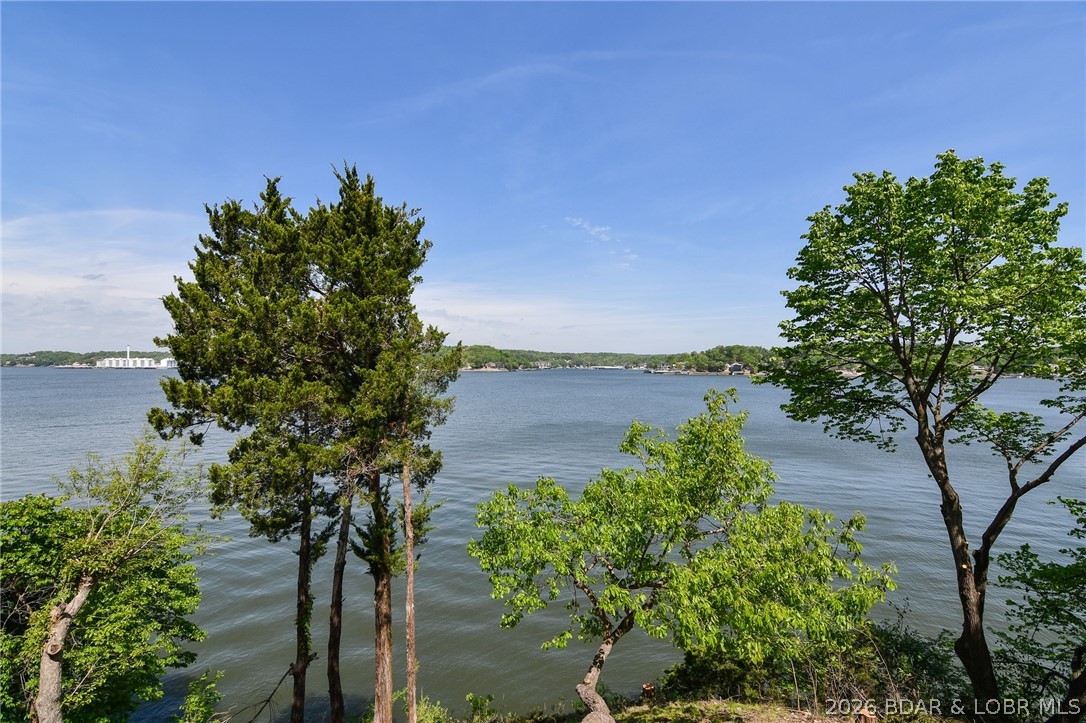 Unmatched Lake Views & Lake Living at Its Best! Take in breathtaking 180-degree views up and down the main channel from your oversized deck—perfect for watching boats cruise by and spotting eagles soaring over the Lake of the Ozarks. This 2-bedroom, 2-bath condo comes mostly furnished. Inside, you’ll find an inviting layout with kitchen featuring newer stainless steel appliances, a spacious pantry, and a pass-through window to the dining area—ideal for entertaining. One bathroom has been nicely updated w/ a newer vanity and countertop. Step outside to your recently replaced, oversized deck that truly feels like you’re right over the water. The 10x28 boat slip (Dock B, Slip 9) is conveniently located in the closest dock to shore, making lake access easy. Copper Ridge is a hidden gem—a smaller, well-maintained complex with no rentals, offering a peaceful setting along with great amenities including a community pool, lakeside gazebo on the point, and brand-new docks. Conveniently located near Bagnell Dam, plus shopping, dining, entertainment, and state parks by both land and water. This is the lake getaway you’ve been waiting for—don’t miss your chance to make it yours this summer!