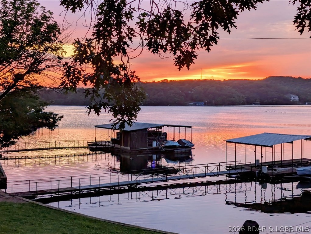 New Price! OPEN SATURDAY 11-2pm
 Great opportunity to own your own piece of the lake. Beautiful lakefront, level Property on the quiet side of the lake. 2 Levels of family living or  easily conform into 2 STR properties. Each floor has a Kitchen, Full bath, Family Room & 2 large bedrooms and lower level has a Murphy bed for extra sleeping. Just freshly painted and selling turn-key, very nicely furnished. New Electric Fireplace (2026), Hardwood floors (mail level) & Luxury Vinyl (2025) Lower level. New Sliding glass doors Lakeside, Family Rm & Master Bedroom (2025) 3 out buildings, 2 car garage, 1 car garage and 1 car Shop all have overhead doors. Rhino Shield/Ceramic Coating Exterior (2025) on all buildings, No exterior maintenance needed for 20-25 years. 12 x 28 Boat Dock with 6000lb lift and Wet Steps included.