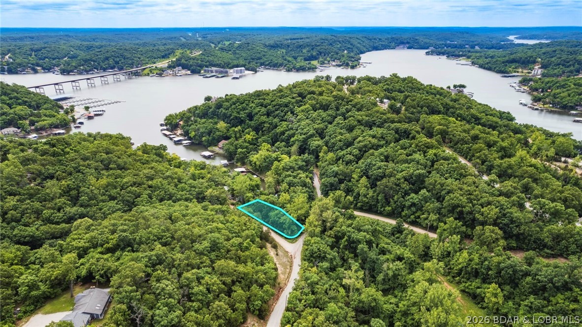 Own a Corner Lot on the legendary Lake of the Ozarks in Camden County, Missouri. Lot 13 in El Tampa Acres is 0.49 Acres +/- and offers Road Frontage on both Tulip Drive and Petunia Road, providing flexible access and Building optoins. A portion of the Southern boundary adjoins the Niangua Arm of Lake of the Ozarks. This creates an attractive setting for a Primary Residence, Vacation Home, Cabin, Tiny Home or Investment Property. Power is available at the Property, with underground telecommunications infrastructure nearby. Ameren Missouri has indicated a Dock may be possible, subject to its permitting requirements, with current guidelines allowing an approximate extension of 6 to 13 feet lakeward from the shoreline, including the walkway. This Property in conveniently located minutes from Camdenton, Osage Beach, Marinas, Golf, sShopping, Dining and Recreation.