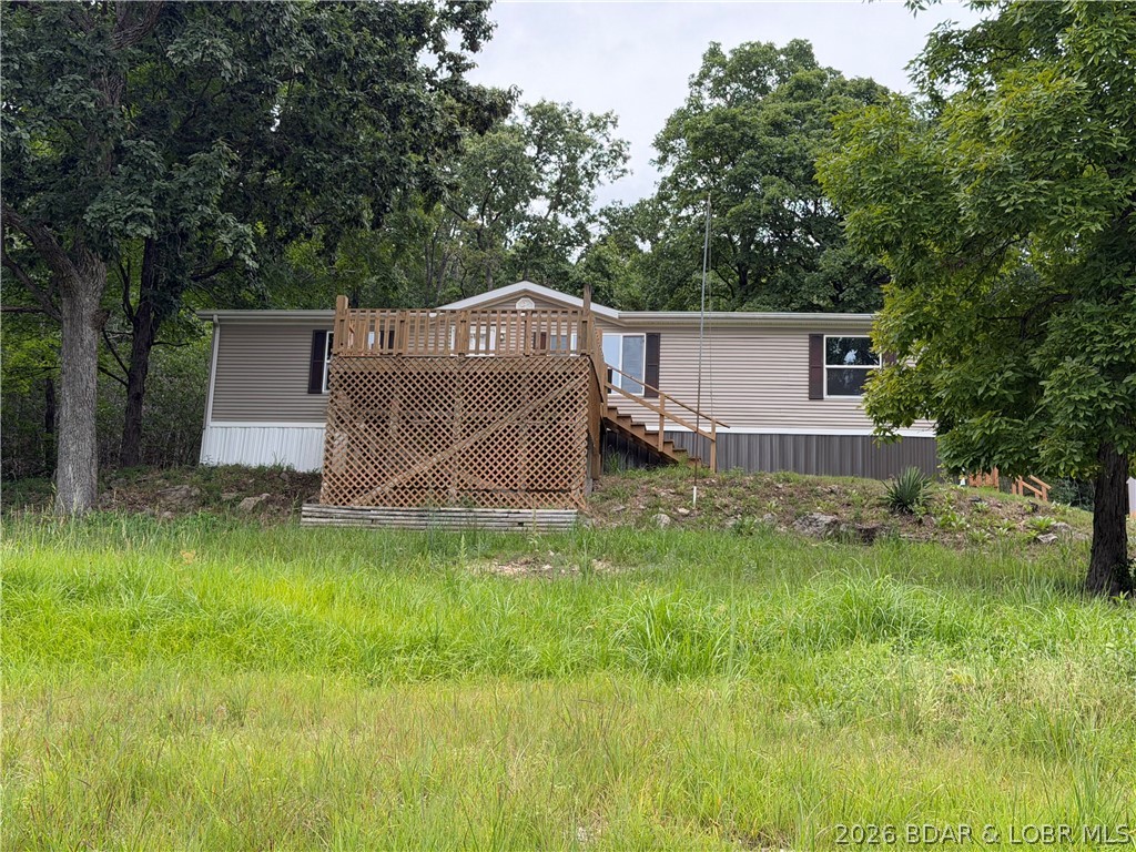 Enjoy beautiful Lake of the Ozarks views and abundant wildlife from this well-maintained 3-bedroom, 2-bath manufactured home on over 3 acres located on the second tier. The home has received numerous updates, including new windows, flooring, decking, kitchen appliances, cabinets, countertops, sink, leaf guard gutters and more.

Tucked away in a semi-private setting, this property offers ample wildlife and peaceful surroundings. Watch deer from the dining room or enjoy convenient access to hunting right outside your back door. With scenic lake views, updated living spaces, and plenty of natural beauty, this home is ideal for a full-time residence or relaxing lake getaway.
Plenty of room to build a garage 
 
Please note: The driveway is steep and may require a four-wheel-drive vehicle during inclement weather.