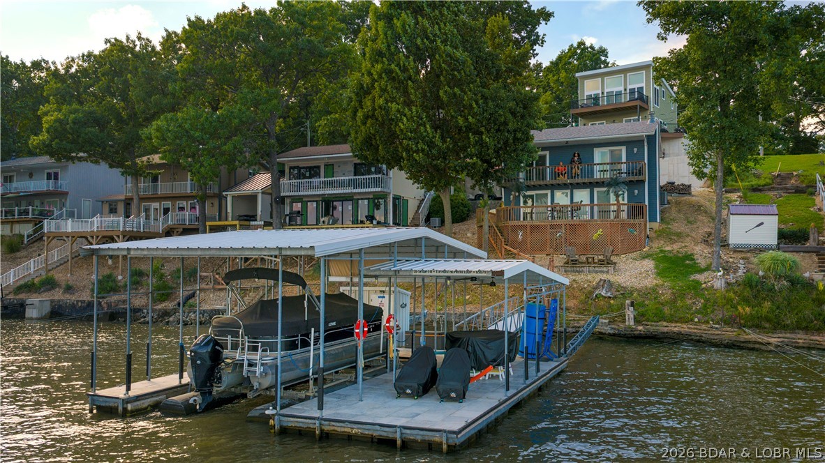 Welcome to your waterfront escape at the 27MM!This lakefront home is perfectly positioned off the main channel, offering breathtaking views, deep water, & the ideal setting for making memories at the lake. Inside, you'll find 3 spacious bedrooms & an inviting open-concept living area highlighted by a cozy wood-burning fireplace & walls of windows that flood the home with natural light. 2 of the bedrooms open directly onto the deck, allowing you to step outside and take in the view whenever you please. Outdoor living is what truly sets this property apart. Enjoy two lakeside decks, including a covered deck & a martini deck just steps from the water. The engineered rough water dock features a 14x30 slip with the ability to convert to a 34ft, convenient dock storage, & an uncovered section perfect for sunbathing & swimming. With the prime location, you'll have easy access to some of the lake's favorite waterfront dining destinations. Whether you're looking for a full-time home, weekend getaway, or investment property, this lakefront retreat offers everything you need to enjoy your days at the lake. Need more rooms? Need a garage? See MLS#3587797 for full package deal.