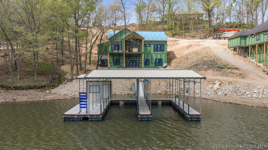 COMING SOON! Don’t miss this rare opportunity to own a BRAND NEW lakefront home on 122 ft of shoreline—while it’s still under construction! Buy now and personalize the interior finishes to match your exact style and vision. Perfectly positioned in a cove with deep water and stunning main channel views, this property truly has it all. A brand-new dock with two 12x32 slips is already in place and ready for use. Thoughtfully designed, the home features 7 bedrooms, 5.5 baths, and a 3-car garage. The main level offers a luxurious primary suite, chef’s kitchen with large island, lakeview dining, and seamless access to a covered patio plus open grilling area. The lower level includes 5 bedrooms, 3 baths, a spacious family room, wet bar, and flex space ideal for a golf simulator, gym, or wine/bourbon room. Enjoy a gentle walk to the dock, no HOA, shared well, and private septic. Your dream lake home starts here!