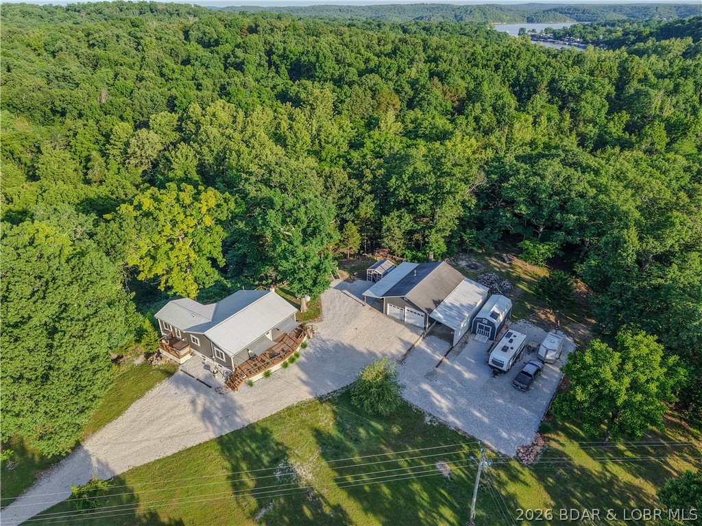Lake area retreat on 3 acres with garage/RV setup, updated main level, and lower-level income or guest potential. Main level features 2 bedrooms, 1.5 baths, a bright and welcoming large living room, sunroom with pellet stove and Updated kitchen cabinets, butcher block counters and smart appliances. The sellers have taken exceptional care of the home during their ownership, with fresh paint, thoughtful updates, new windows, gutters and a clean, well-maintained feel inside and out. The primary bedroom with half bath and private deck that leads to your hot tub area were you can relax after a day at the lake. The finished lower level adds even more usable space with living area, partial kitchen, exterior entrance, interior access to the main level, and unfinished storage space. A bedroom and full bathroom with washer/dryer hookups in place, makes it easy to rent for some income. Outside, the garage and RV setup are the true standout features with water hookups and 1000 gal septic tank. It includes 24x40 2+car garage, 12x14 carport, 12x26 side garage with auto door and a new chicken coop. Boat ramp access within 2 miles. Schedule a showing today.