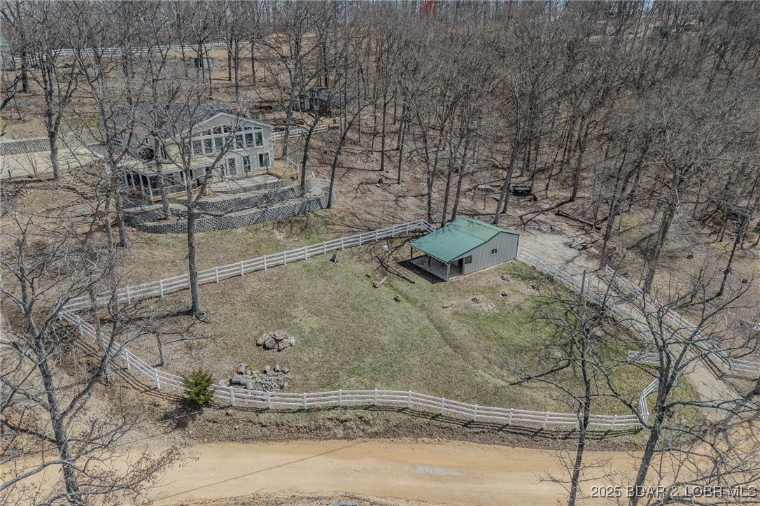 PRICE IMPROVEMENT!!  Hobby Farm, Animal Lovers & Lake Enthusiasts—28 Delancey St is for YOU! This 4 ac (+/-) property features a gentle lakefront lot, horse stable w/ 1/2 ac field, & large shop for equestrian or hobby farm storage. The lower barn offers 2 stalls, concrete floors, stable doors, shaded overhang, & a grazing area, all enclosed with 1,000’+ of white vinyl fencing. The chicken condo has inside flock access, storage, & egg collection. Raised garden beds & a nearby greenhouse make growing your own produce easy. Inside, the kitchen boasts granite countertops & stainless appliances; the main floor primary suite offers a walk-in closet & spa-like bath. The living room’s vaulted pine ceilings & wall of windows overlook lakefront grounds. The lower-level study & family room provide work-from-home or leisure space, while the guest suite offers privacy with an en suite bath. Enjoy a beach & dock in a protected cove for swimming, fishing, & fun. A 1,548 sf heated/cooled garage offers a diverse use of space for vehicles, entertaining, & personal interests. 28 Delancey St is a ONE of a KIND property...More than a home—it is a lifestyle of comfort, utility & lakefront bliss.
