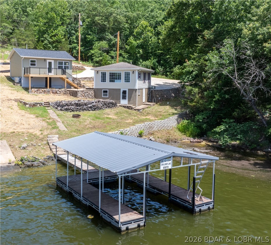 Not one house, but two houses! These homes offer great rental potential, a multi-generational lake retreat, or the option to enjoy one home while renting the other. The 1 bed, 1 bath home is completely new, built in 2026 on the existing foundation. This home is heated and cooled by a mini-split unit. It features vaulted ceilings in the kitchen and living room, plus a deck overlooking the main channel of the Gravois arm. The second home is 2 bed, 1 bath, and was fully renovated in 2020 and has central electric HVAC. The homes are on the same parcel and must be sold together. Also included is a 5-year-old, one-well dock that's easy to access from the level backyard. When the water is lower, a sandy beach emerges where kids love to play. Enjoy main channel views with a cove-like feel and plenty of space to relax and play in the water. These homes are just a short boat ride from Jolly Rogers, Coconuts, and Lake Burger. Another bonus, is a huge amount of parking located on the property, right near the homes. Both homes have laundry hookups, full kitchens, a shared well, and septic. Enjoy the clean feel and peace of mind that come with everything being new or thoughtfully updated.