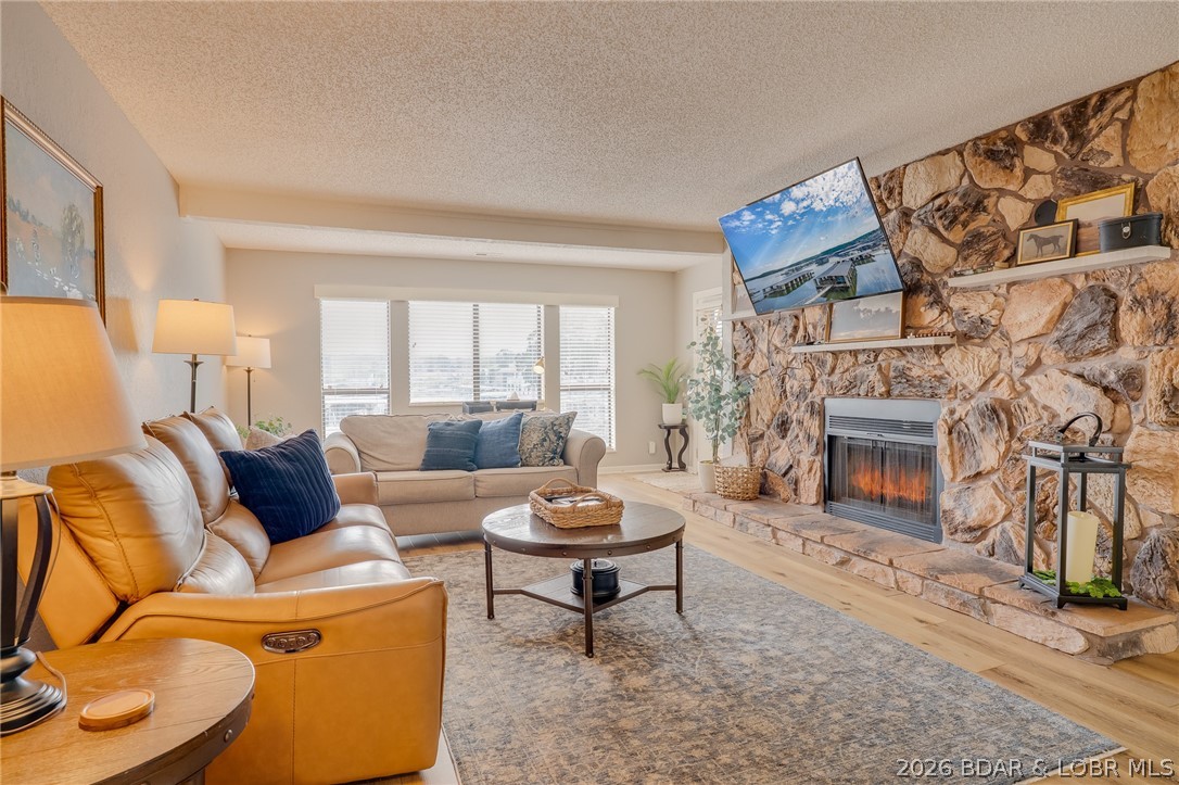 Be just steps from one of Lake of the Ozarks' most exciting new destinations! This top-floor 2-bedroom, 1.5-bath condo is within walking distance of the new lakefront resort and entertainment district being developed near the Grand Glaize Bridge, featuring planned restaurants, shopping, entertainment, and family attractions. Located in the heart of Osage Beach, this Turn-key 1,338 sq. ft. condo offers an open floor plan,  abundant natural light, and a stunning floor-to-ceiling stone fireplace. Relax on your private deck with beautiful lake views and spectacular sunsets, or enjoy the community pool, sandy swim beach, swim platform, and 10x20 covered boat slip. Nightly rentals allowed with an established rental history make this an excellent investment or personal getaway. Recent updates include LVP flooring (2022), roof (2025), furnace (2023), deck and porch (2025), water heater (2024), and dishwasher. Convenient to the Lake's best dining, shopping, golf, and entertainment by land or water.