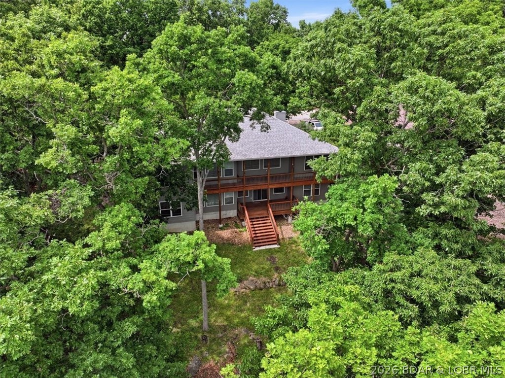Welcome to this spacious 5-bed, 3-bath home in the highly desirable Four Seasons community, offering year-round lake views and over 2,700 sq ft of finished living space. The main level features vaulted ceilings, a cozy fireplace, ceiling fans throughout, and abundant windows that fill the home with natural light and frame beautiful lake scenery. Enjoy main-level living with 3 bedrooms and 2 bathrooms, plus a separate dining room and a charming breakfast nook overlooking the water. The finished walkout lower level adds even more versatility with 2 additional bedrooms, 1 bathroom, and a large open area perfect for a family room, game room, office, or hobby space. The home backs to peaceful green space, ensuring privacy with no close neighbors behind you. A 3-car attached garage provides excellent storage units and tool organizers that stay with the home. Major updates include a new roof and new HVAC system. As part of Four Seasons, you’ll enjoy walking paths, pools, tennis and pickleball courts, a campground, gym, trailer parking, and more—an exceptional blend of comfort, views, and amenities in a premier Lake Ozark location.