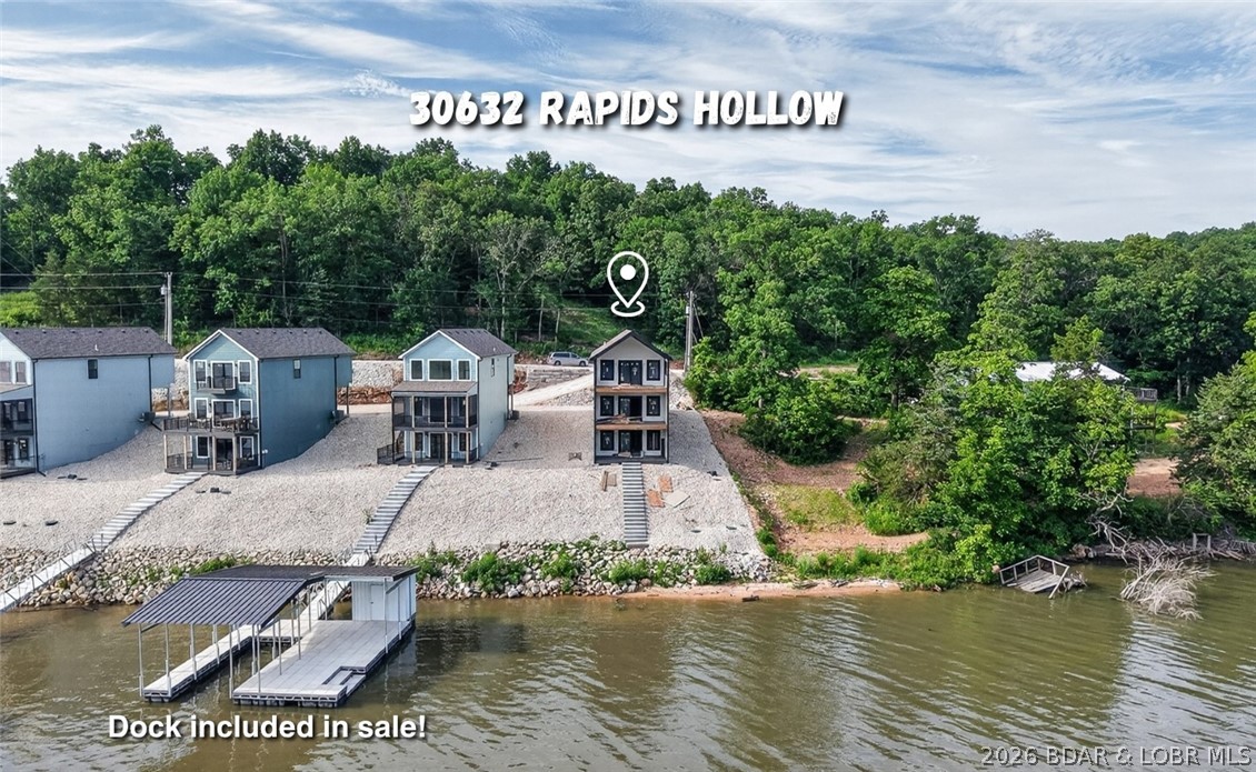 BRAND NEW LAKE HOME AND DOCK!!! The perfect blend of modern design and lake living, and MOVE IN READY!!! Located in Proctor Cove on the 55 Mile Marker, this large cove is perfect for swimming, kayaking, paddleboarding, and the fishing is top notch! The home is designed for comfort and functionality with flat parking, two living areas, and plenty of outdoor space with composite decks on all three levels (plus the main level deck is screened!). Inside, you’ll love the gorgeous kitchen featuring custom cabinets, quartz countertops, an island, sleek finishes, and stunning backsplash. Upstairs features two master suites while the finished lower level offers a third bedroom and a full bathroom. Whether you’re enjoying the water, relaxing on the deck, or entertaining, this home was built to enjoy lake life. The yard is rocked for low maintenance and high speed fiber optic internet is available! One-well dock with 70 ft ramp features a 10x26 boat slip (can be opened up to 32 ft slip) with a huge swim platform and built in dock steps to the water and a 6x10 shed. Tons of space both in the shade or out in the sun!