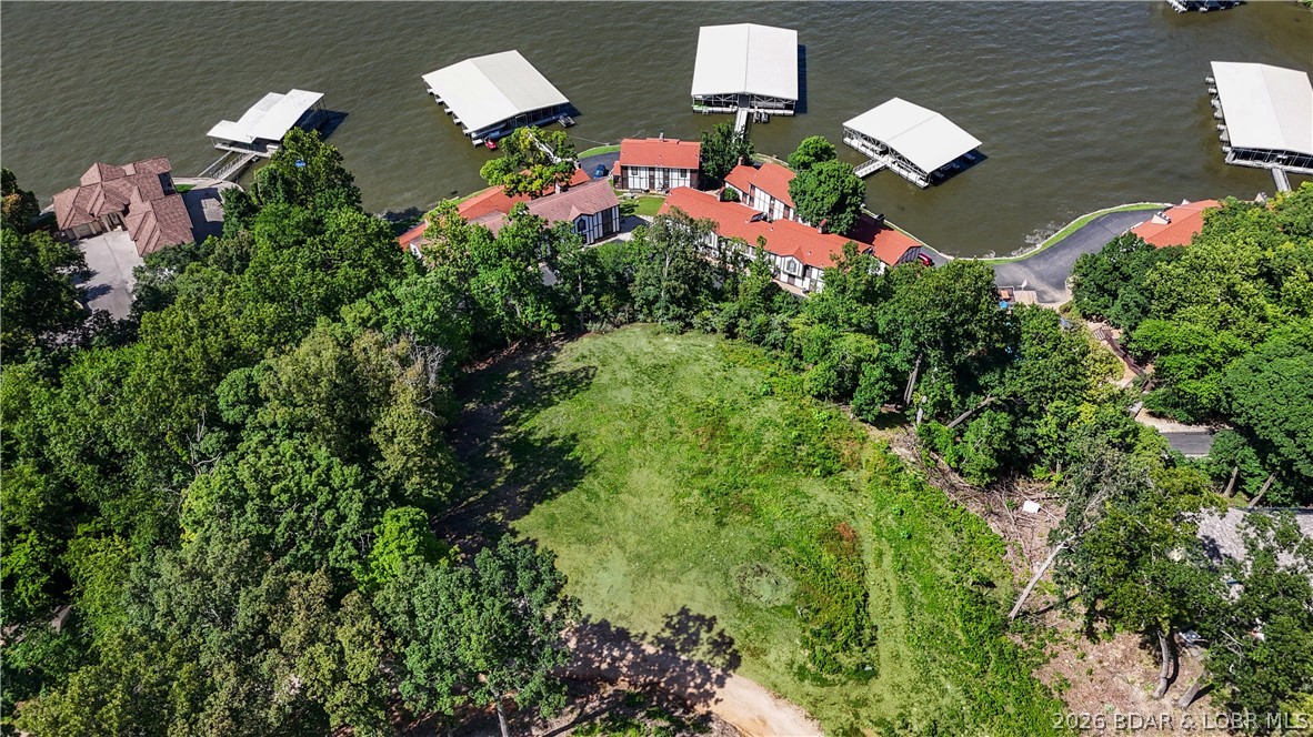 Welcome to the premier building site in Osage Heritage, the exciting new development perfectly positioned between Osage Beach and Camdenton. These are the two best lots in the entire subdivision—a rare double-lot opportunity offering an expansive, unobstructed panoramic view of the 30-mile marker on the Osage Arm of Lake of the Ozarks. Surrounded by almost exclusively new construction homes, this parcel promises both long-term value and a fresh, upscale neighborhood feel. The lot has already been professionally cleared, surveyed, and staked, saving you time and money—and comes complete with approved blueprints, meaning you can start building your dream home almost immediately. Whether you’re planning a full-time residence, vacation getaway, or investment property, this homesite delivers in every way: location, views, neighborhood quality, and build readiness. Utilities—including sewer, wi-fi, and electric—are available. Don’t miss this rare opportunity to claim one of the most desirable properties in Osage Heritage. Start building your lake life today!