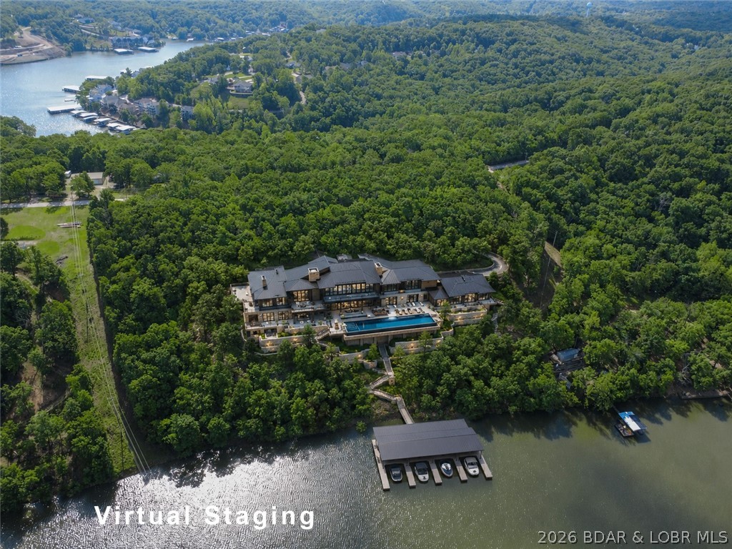 Discover this rare 9+ acre lakefront land 5 minutes from Camdenton at the Lake of the Ozarks, offering 585 feet of pristine, deep-water shoreline in a sheltered cove—perfect for your dream estate or high-return development. Currently configured as four parcels with 11 platted lots, this versatile tract would allow subdivision into many lots, build one large estate, or apply for rezoning to R-3 for condos/multifamily to capitalize on surging demand. Enjoy established infrastructure: roughed-in roads, 853 feet of paved Bear Paw Road frontage for seamless access, a drilled well with well-house at the entry, and ample space for docks while maintaining stunning views. By boat, you're just minutes from vibrant spots like Four Corners, The Cave Bar & Grill, Larry's on the Lake, and Fish & Company; by road, Camdenton and Sunrise Beach deliver shopping, dining, and entertainment nearby. In today's robust 2026 Lake market—with limited inventory fueling strong interest in waterfront properties—this exceptional multi-lot opportunity stands out for custom homes, family compounds, or profitable investment. Motivated seller—bring your offer now!