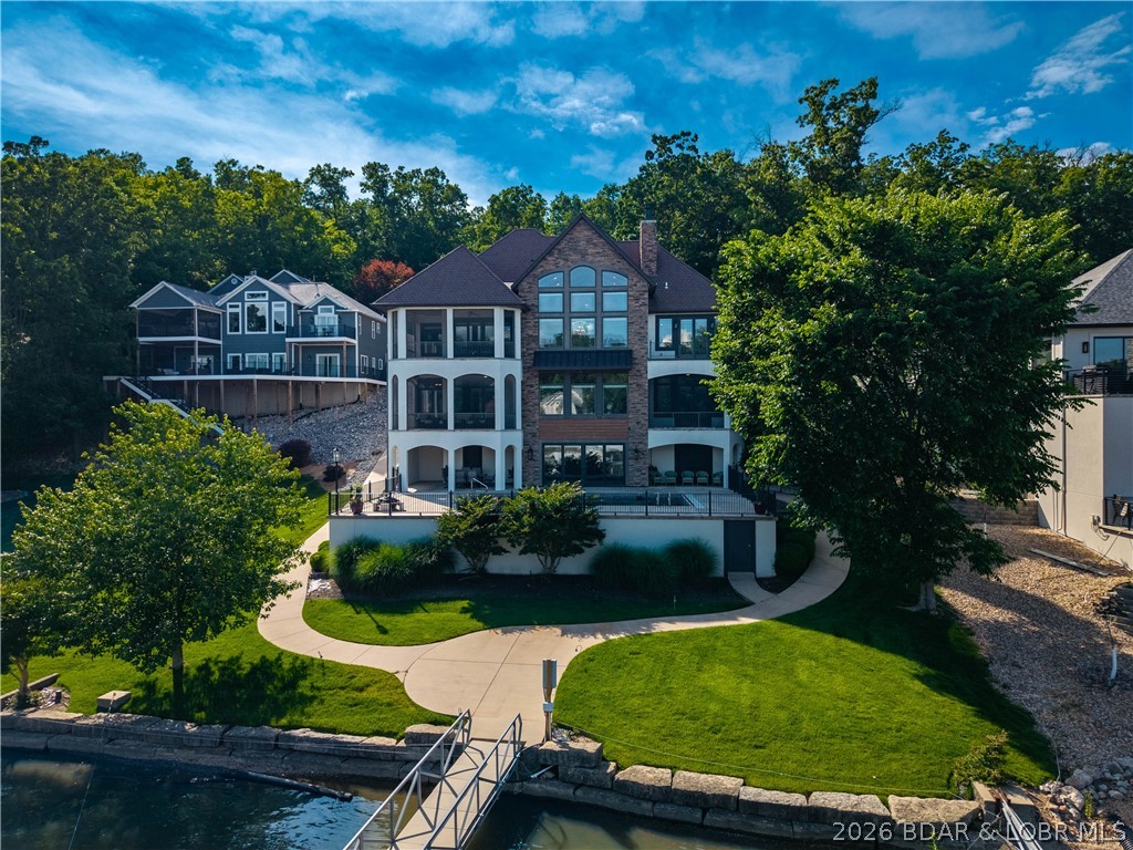Custom-Built Lakefront Home in Sunrise Beach by Thomas Construction! Brand New Roof coming! Exceptional retreat showcases outstanding craftsmanship, stunning custom woodwork, & breathtaking lake views.Open-concept floor plan features a soaring vaulted ceiling w/exposed beams,beautiful stone gas fireplace, high-end appliances, dining area that opens to a screened deck. Main-level living, the primary suite is complete w/ custom tile work, a walk-in shower, & walk-in custom closet system. The great room offers panoramic lake views. Lower level features an expansive family room w/full bar 3 en-suite bedrooms, 5th bedroom/office. Step directly outside to the heated saltwater pool w/automatic cover & fountains, perfectly positioned lakeside. Additional highlights:large storage room,safe room/wine cellar, golf cart path from driveway to the dock, oversized 2-car garage w/ room for expansion.Level lakefront lot offers a great dock envelope w/large concrete dock & cruiser slip in a protected deep-water cove.Great for full-time,second home,or VRBO. Conveniently to all the amenities & access to Porto Cima & Four Seasons amenities. Being sold turn-key w/ several recent updates. One Newer HVAC.
