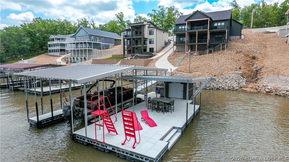 Whether you are enjoying a rainy afternoon on the covered decks, hosting friends at your dock, or exploring nearby favorites like Fish & Co., Bulldogs, or Nauti Fish, this custom-built lakefront ranch is the ultimate getaway. Completed in mid-2025, this home is tucked away in a quiet, year-round deep-water cove. Designed for living & entertaining, main level open concept features 2 bedrooms, including a primary suite w/ a dreamy oversized walk-in closet. The chef’s kitchen is equipped w/ an awesome walk-in pantry for all your storage needs, a wine/beer fridge an island seating space perfect for holiday hosting or Sunday Fundays. Enjoying watching games on the covered deck TV & gas line for grilling. A massive family room anchors the lower level, complete w/ wet bar, built-in ice maker & 2 additional bedrooms. The 2.5-car garage includes a workbench area & room for 2 cars plus a side-by-side. Built for lake life, golf cart path leads you to the entertaining dock features a built-in bar & large swim platform. If you want to add a pool there it has the perfect backside space, see virtual picture.   The home comes partially furnished for immediate enjoyment. Come check out the sunsets.