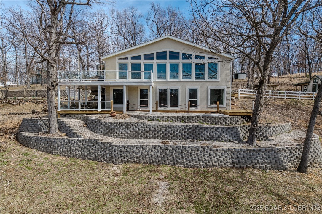 PRICE IMPROVEMENT!!  Discover the ultimate blend of lakefront living & versatile country charm at 28 Delancey St in Sunrise Beach! This unique 4 ac (+/-) property at the 27 MM offers a rare combination of lake access, gardening space & modern comforts- perfect for those seeking both relaxation & adventure. The 3,194 sf home w/ granite countertops & stainless steel appliances offer a sleek, modern feel. The main floor primary suite has a spacious walk-in closet & spa-like bath, as the living room boasts a wall of windows overlooking the lakefront grounds & vaulted pine ceilings. The lower-level study & family room is ideal for work-from-home or casual relaxation. And the guest suite offers privacy for visitors w/ an en suite bath. The lakefront beach w/ dock is in a protected cove for swimming, fishing & water fun. The 1,548 sq ft heated/cooled garage was created for the grandchildren craft projects and includes a gardening cubby & loft space. You Deserve It! This multi-faceted property is more than just a home- it's a lifestyle. From the modern interior to the thoughtfully designed outdoor spaces, 28 Delancey St offers the perfect mix of comfort, utility & lakefront bliss.