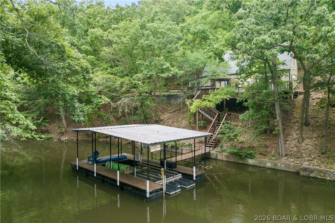 Have you always dreamed of owning a lakefront home? Seize this incredible opportunity at an unbeatable price! Nestled in Sunrise Acres 1 at the 9MM, this tranquil and private open-concept residence features 2 bedrooms and 1.5 bathrooms, perfectly designed to maximize your lakefront experience. Enjoy 100 feet of cove-protected lakefront situated near a convenient boat ramp.
The outdoor space is an entertainer's dream, boasting an expansive deck area and a single-well (10x24) dock complete with a 10,000-pound hoist. Additional property highlights include ample flat parking, low-maintenance city water and sewer hookups, and quick access to a variety of nearby amenities. While nightly rentals are not permitted, long-term rentals (14+ days) are allowed, offering excellent flexibility and investment potential for savvy buyers. Whether you are looking for a peaceful full-time residence, a private weekend getaway, or a steady long-term income producer, this turn-key property delivers the perfect lakefront lifestyle. Don't miss your chance to own a piece of the lake at an affordable price point—schedule your private tour today!