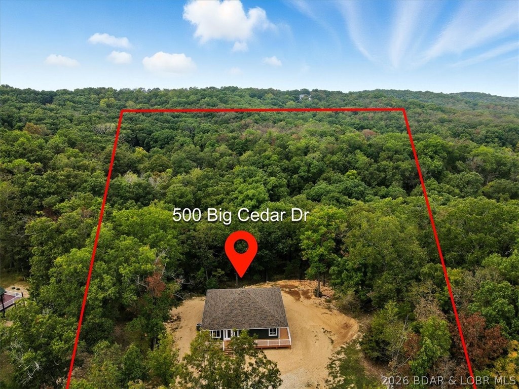 New construction, acreage, gated entry, and resort-style amenities — this one checks all the boxes! Located on 5 private acres in a luxury community next to Old Kinderhook, this 4-bedroom, 3-bath home offers flexibility for full-time living, a second home, or a short-term rental investment (other homes have a great nightly rental record!). The open-concept main level features vaulted ceilings, spacious kitchen counter area, the owner’s suite and bath, a second bedroom plus full bath. The lower level adds a second living space, two additional bedrooms, a third full bath, and laundry. Outdoor living is a standout with the large wraparound deck and covered lower patio with hot tub included, perfect for entertaining and enjoying the surrounding nature and wildlife! Flat parking and tons of room to build a shop. Community amenities include a new clubhouse, indoor and outdoor heated pools, fitness center, spa, pickleball courts, and maintained streets. Just minutes to Camdenton square, Ballparks National, golf course, on & off water restaurants, and more! Furniture, appliances, golf cart, and hot tub included!!! (Road will be asphalted after construction.)