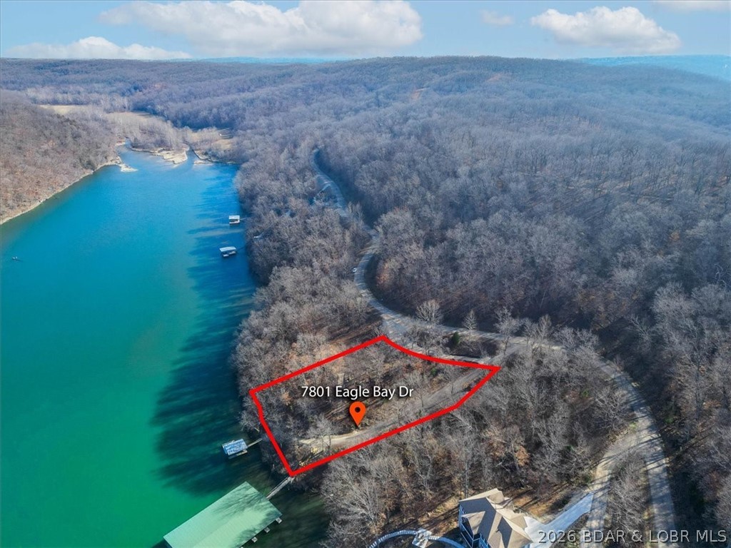 Prime 1.3-Acre Lakefront Canvas: Build Your Dream at Eagle Bay! Seize the rare opportunity to own a premier 1.3-acre lakefront lot in the prestigious Eagle Bay subdivision of Gravois Mills. This exceptional property offers 226 feet of pristine shoreline on the tranquil waters of the 55MM, providing the perfect balance of serene privacy and convenient access to local waterfront dining and city amenities. Already professionally cleared and primed for construction, this lot is a true "ready-to-build" gem waiting for your custom architectural vision. The groundwork has been laid for immediate enjoyment; the property is already equipped with a sturdy wooden dock featuring a 10x24 boat slip. Enhancing its incredible value, electric/sewer/water/fiber connections are already available on-site, significantly streamlining your building process. Whether you envision a sprawling multi-generational estate or a sophisticated modern retreat, the expansive footprint and gentle topography offer endless possibilities. Take the plunge and secure your slice of paradise in one of the lake's most sought-after communities. Schedule your private tour today and start living the lifestyle you deserve!