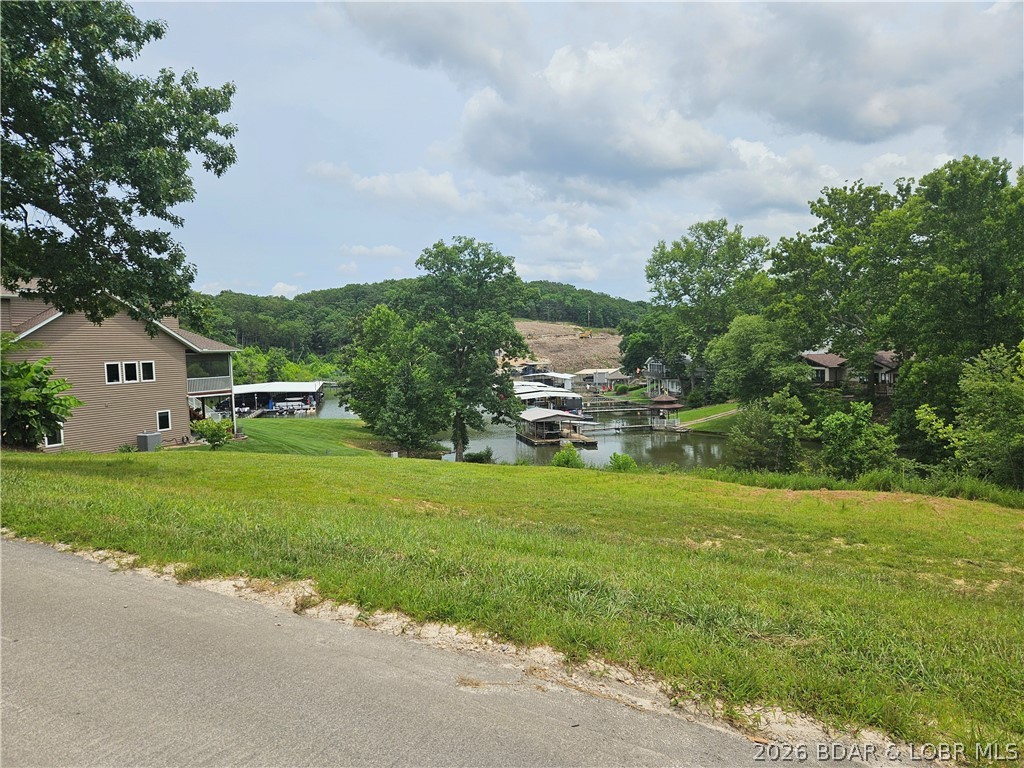 Ready to build on an almost level lot with central water & sewer, dock slip and pwc spot in a quiet cove. The subdivision has a clubhouse, pool and sand beach. Close to restaurants, banks, shopping & entertainment.  Single family dwellings only and building plans must be approved.  Access to the clubhouse and pool is restricted until a foundation is poured on your lot.  Walking distance to the Nauti Fish and minutes by water to the Cave Bar & Grill and Larry's.