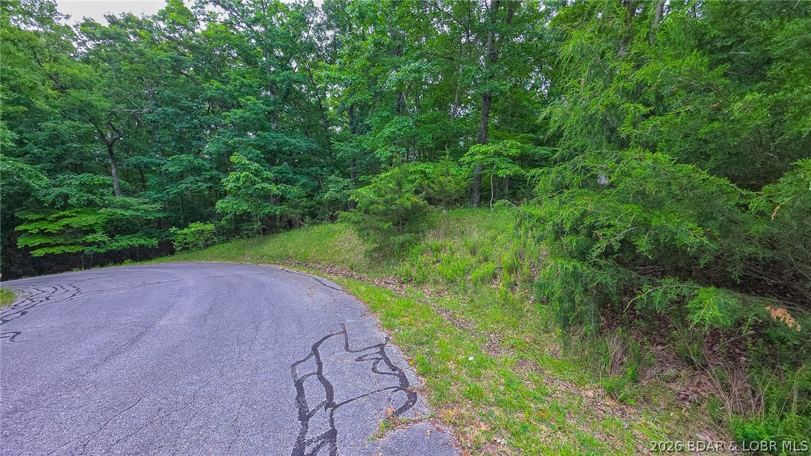 Embrace the perfect blend of natural tranquility and luxury community living with this exceptional 1.69-acre lot (Lot 850) situated on Grand Cypress Court in Sunrise Beach, Missouri. Boasting 87 feet of road frontage on a quiet cul-de-sac curve, this gently to moderately sloping, beautifully wooded parcel is nestled in a more serene, less developed pocket of the highly sought-after Porto Cima community, offering maximum peace and privacy. It serves as an ideal canvas for your dream home, with flexible POA guidelines requiring a minimum of just 1,100 square feet (or equivalent to surrounding homes), and the added convenience of water and sewer agreements already in place. As a resident, you will enjoy unparalleled lifestyle perks, including premier Porto Cima community amenities like lake access, pristine pools, playgrounds, and an exercise room, alongside exclusive access to the Four Seasons amenities. Don't miss this rare opportunity to secure a generous acreage tract and build your custom retreat in one of the Lake of the Ozarks' most prestigious communities.