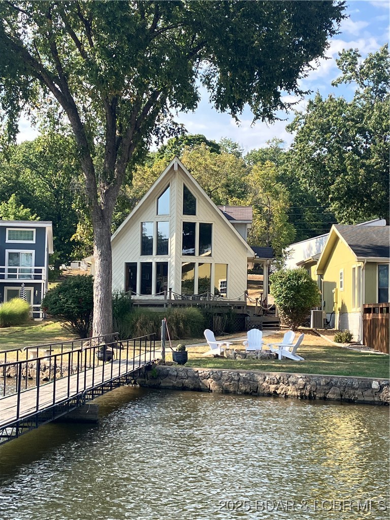 <<<LEVEL LEVEL LAKEFRONT LOT>>>  A wall of windows and vaulted ceilings. Main level living! Big view from this COVE location looking out to the main channel. Main level living includes - Primary bedroom, kitchen 
, living room, laundry, and full bath, along with 2 car garage entrance all on the main level! A large guest bedroom and loft bedroom located on the second level with a full bath. New granite counters in the kitchen, newer stainless steel appliances, newer light fixtures and ceiling fans. Two car attached garage. Enjoy the sun coming up in the mornings and shade on the large deck in the evening. Large dock included.