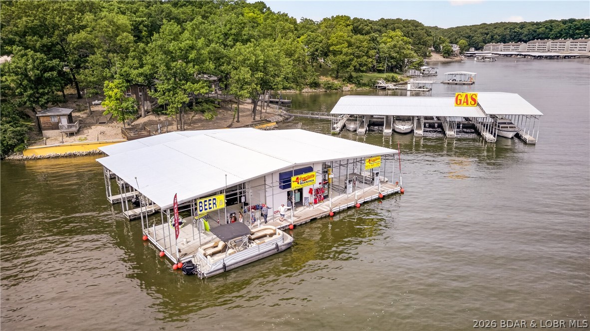 Investment Opportunity at Lake of the Ozarks – 3 Mile Marker, North Shore! Rare chance to own a marina w/tremendous upside potential.This unique waterfront property offers multiple income streams & possibilities for expansion. The property features 20 boat slips, boat ramp, service dock, swim platform, ample parking & a 40x60 shop building ideal for marina operations, storage or additional business opportunities.The fuel dock has been updated with new gas dispensers, new upper level septic & new well pump is ready for a new owner.Included on the property is a charming lakefront home currently operating as an Airbnb, 2 additional rental homes providing steady income, & 4 RV spaces. With room for development and expansion, this property presents a rare opportunity to create a premier waterfront destination. Whether you're looking to expand a marine business, develop additional rental accommodations or build your vision of the ultimate Lake of the Ozarks marina, this property offers the location, infrastructure and potential to make it happen. Marinas with this combination of waterfront acreage, existing income, expansion potential & prime North Shore location rarely become available.