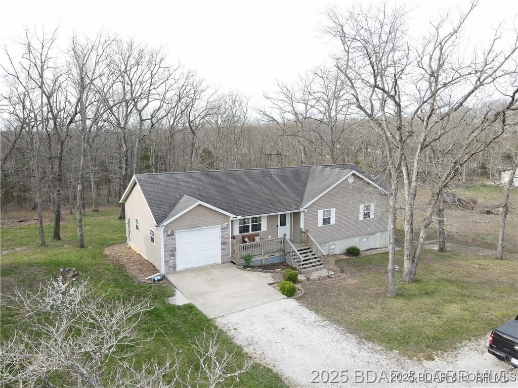 Welcome to your dream home in Gravois Mills! This delightful 3-bedroom, 2-bathroom home built in 2006, offers 1,386 square feet of comfortable living space on a spacious lot. The open floor plan greets you with vaulted ceilings and abundant natural light, enhancing the grand feel of the living, kitchen, and dining areas. Enjoy a large primary suite featuring a full bath with a jetted tub, tile floors, and ample storage. Two more generously sized bedrooms provide plenty of space for family or guests. A second full bath also boasts tile floors and plenty of storage. Laundry is conveniently located off the kitchen in the mudroom, which leads to a one-car attached garage. Step out onto the back deck, perfect for BBQs or relaxing while watching the children play in the expansive backyard. The property features paved roads and access to high-speed internet, ensuring modern convenience. Seize this opportunity to own a beautiful home that combines comfort, style, and functionality in a serene location. Don’t miss out on making this incredible property yours!