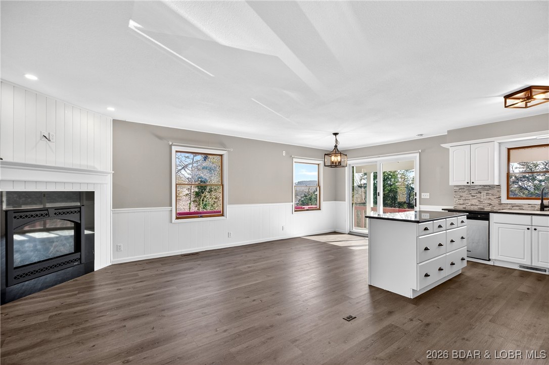 Thoughtfully updated two-story home in a prime location next to Old Kinderhook Golf Course, featuring scenic views of the Lake of the Ozarks. Updated two-story home ideally located next to Old Kinderhook Golf Course, offering beautiful views of the Lake of the Ozarks. The main level features an open-concept layout with three bedrooms and two-and-a-half baths, highlighted by new LVP flooring, granite countertops, updated light fixtures, and a newly installed gas fireplace. The walkout lower level includes an oversized bedroom, full bath, utility/laundry room, and a spacious family room that opens to an almost level yard. A detached two-car garage adds convenience. Recent upgrades include a new HVAC system, roof, flooring, two fireplaces, new appliances, and more. A fantastic home in a prime location close to all the lake amenities.