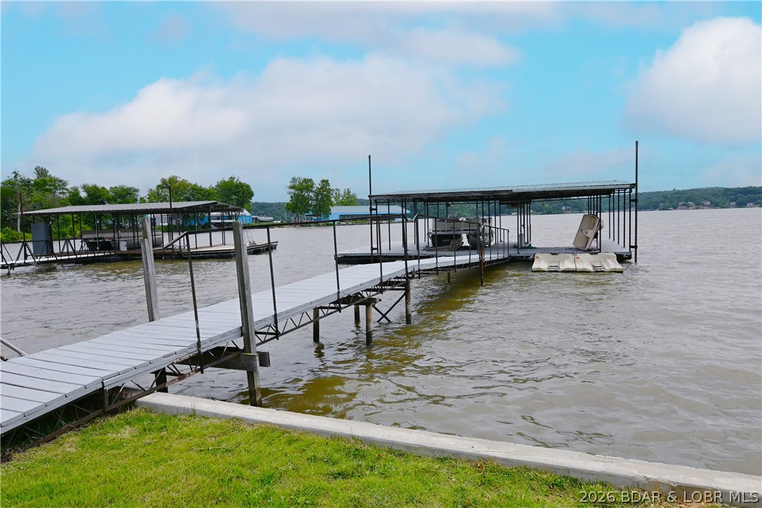 Lakefront opportunities like this don't come around often! Situated on the 60 MM of the Lake of the Ozarks, this well-maintained 4-bedroom, 2-bath ranch home offers approximately 1,800 square feet of comfortable living space and 200 feet of shoreline on a rare, flat lot. Enjoy exceptional waterfront amenities with 2 private docks featuring 3 boat slips and 2 PWC slips—all included with the property. Boat ramp is located directly next to the property. NO RESTRICTIONS OR HOA so feel free to park your RV or trailers on site without being hassled.

The home has seen numerous major updates, including a new roof (10/2024), new furnace (11/2025), new water softener (12/2025), and updated septic system with new lateral lines, providing peace of mind for years to come. Outside, you'll find incredible storage and workspace options with a 30x50 shop, detached 2-car garage, and additional carport. Best of all, there is NO HOA, meaning no dues, restrictions, or extra fees. Finding this much lake frontage, usable ground, parking, storage, and waterfront infrastructure in one package is extremely rare. Move-in ready and waiting for its next owner to enjoy everything the  lake has to offer!