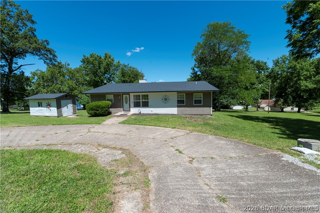 Discover the opportunity to create your own lake-area retreat on 2.31 acres in the Millcreek/Gravois Arm area. This ranch-style home features 2 bedrooms, 2 full bathrooms, central heat and air, well water, newer windows, and a newer roof. The spacious living area opens to an impressive 1,500-sqft deck through sliding doors. The basement offers approximately 1,100 square feet of additional space with plumbing already stubbed for a third full bathroom, providing endless possibilities for future living space, guest quarters, recreation, or storage. Outside, you'll appreciate the circular concrete driveway, mature trees, privacy, and acreage that allows room to roam, garden, or simply enjoy the peaceful lake lifestyle. Whether you're searching for your forever home, summer retreat, or a renovation project, this home offers the flexibility to make it your own. With approximately 2,800 square feet between the main level and unfinished basement, a private one-slip dock, and beautiful water views, this property offers the space, setting, and potential to become something special. Conveniently located just minutes from Laurie with all-blacktop access.