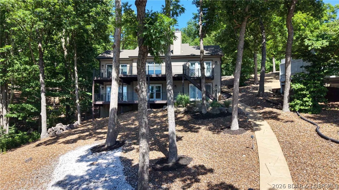 Newly updated lakefront home in Four Seasons, perfect for full-time living or a relaxing lake retreat. Sits on a level lot w/ ample parking. Located in a quiet cove w/ beautiful lake views & community ground bordering one side.. Inside, a wall of windows fills the vaulted great room with light, highlighting the stunning stone wood-burning fireplace & open-concept design. Spacious dining area flows seamlessly into the beautifully updated kitchen featuring high-end appliances, a wine bar, coffee bar, & two pantries. Just off the main living area, the newer oversized deck is great for grilling, entertaining, or enjoying the lake view. The primary suite boasts a vaulted ceiling, custom walk-in closet, & a luxurious spa-inspired bath w/ dual vanities & a wet room featuring a tiled walk-in shower & jetted soaking tub. Half bath completes the main level. Lower level offers a spacious family room w/a wet bar & ice machine, along w/ two private en-suite bedrooms w/ large walk-in closets. Full laundry. Enjoy an easy walk to the two-well dock w/ two hoists included. Additional exterior storage beneath the home for lake toys & equipment. TVs are included. Broker-Owned. Home warranty included.