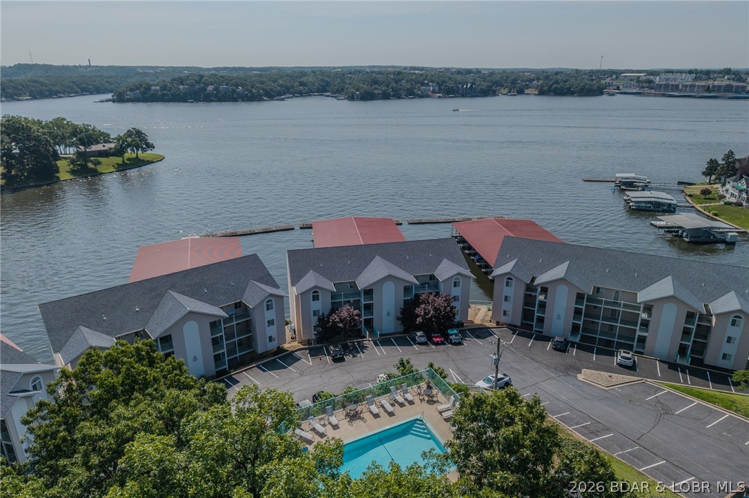 Newly updated, lower level, 3 bedroom, 3 bath, waterfront condo at Harbour Bay!  End unit provides extra privacy and a 3rd bedroom ensuite with electric wall fireplace facing Main Channel. Kitchen with over/under cabinet lighting, decorative wood plank and freshly painted walls & ceiling throughout. 55" TV installed over the tiled electric fireplace. Open floor plan welcomes everyone in living room/dining area and kitchen to be together! Waterfront promenade is only steps away allowing easy access to your 14x40 boat slip and PWC space with drive on lift.  Two primary lakeside bedroom suites that enter onto covered deck with TV. Deep depth cove protection & eastern exposure for afternoon shade.  FANTASTIC main channel view! Harbour Bay is a quiet, smaller gated community allowing annual and semi-annual rental options along with a community pool with killer view of lake! Harbour Bay has some of the lowest assessments on lake.Located centrally by land and water between the Lodge of the Four Seasons and Margaritaville!  Close to Lake Ozark & Osage Beach, the famous Bagnell Dam Strip, grocery stores, theaters and state parks for more lake life! Lake of the Ozarks is the place to be!