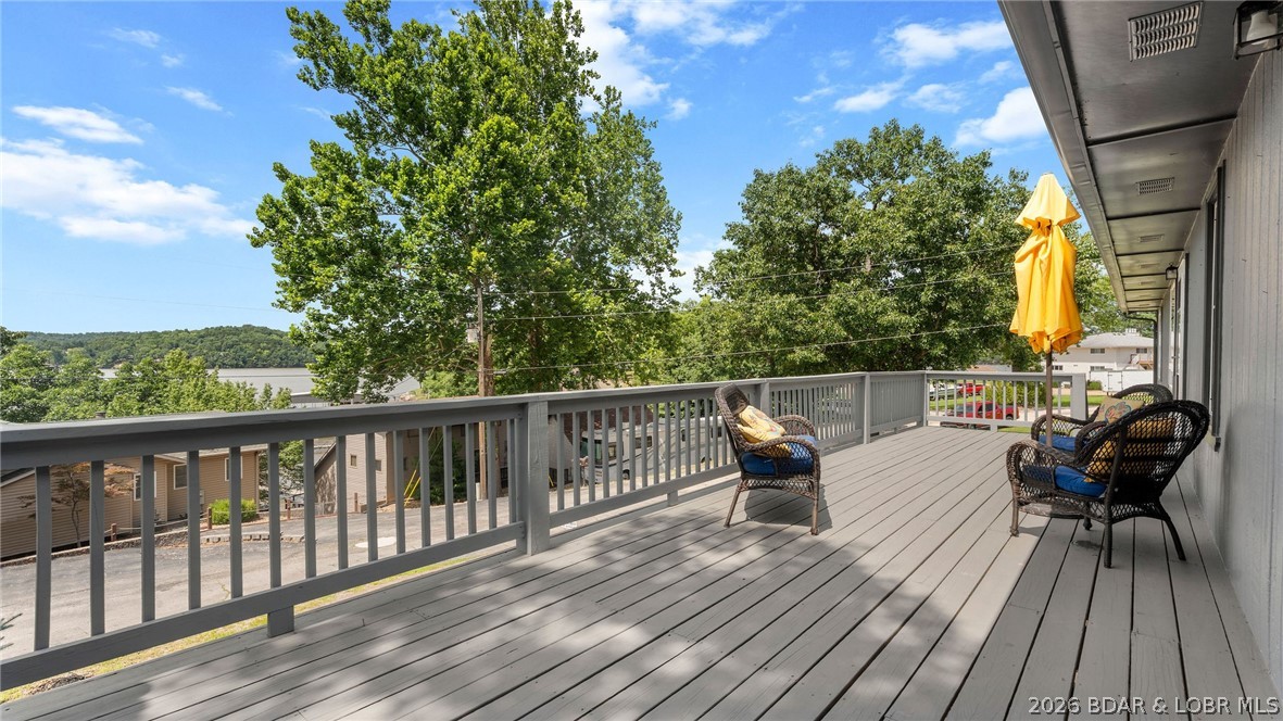 Affordable lake living with the features buyers are searching for—lake views, a 10x20 boat slip, community pool, boat ramp, and plenty of space for family and guests. Located in the desirable Fawn Valley subdivision, this 4-bedroom, 3-bath home offers a flexible floor plan with multiple living areas and a spacious oversized 2-car garage with room for storage, hobbies, or a workshop. The main level features an open living, dining, and kitchen area that flows to the lakeside deck and fenced backyard, creating the perfect setting for entertaining, pets, or enjoying the view. The primary suite, two additional bedrooms, and a full bath are conveniently located on the upper level, while the walkout lower level offers a second living area, fourth bedroom, and full bath—ideal for guests, a home office, or recreation space. Recent improvements include exterior paint, updated flooring, lower-level windows, and deck renovations. While there is opportunity for a new owner to add their own updates and personal touches, the value here is hard to ignore. Enjoy paved roads, high-speed internet, excellent community amenities, and easy access to Lake of the Ozarks, with a gorgeous lakeside deck.
