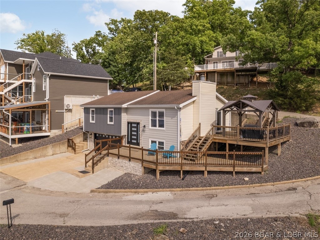 This spectacular home sitting at the one mile marker is one of the main reasons Lake of the Ozarks is so popular. The gorgeous views, & deep water sets the stage for this modern home that is completely updated & shows like a display. From the elegant new fireplace with new stone in the family room to all the newer carpet, updated kitchen, newer appliances, warm colors, decor & top of the line furniture is only a few of the great features this home has to offer. Outside is a large deck with a gazebo to enjoy gorgeous sunsets, attached 2 car garage, & plenty of room for parking. The home has also been updated with a new front door & sidelights, new siding and stone, new deck railing, covered porch over front door, new porch lights & a few more updates are coming. The Lakefront adds a great bonus with flat grassy area, seawall, 115' Lakefront, very large concrete dock that features a 14X36 slip & a 12x30 slip, lots of room for entertaining guests & swimming. This home is turnkey and can be used for vacation rental or just your own private resort. Located just off the Bagnell Dam strip, close to all the nightlife, great restaurants & shopping. View MLS 3587928 for another Lake Home.