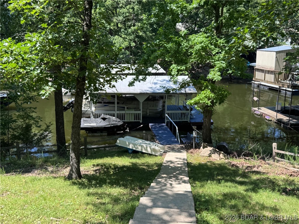 Looking for a Lake Home thay doesn't break the bank....here it is! Affordable & charming property with 70ft of lakefront, Dock & Room to Grow! Nestled among mature trees sits this adorable 3-bedroom, 1-bath single wide lake home offering the perfect blend of charm and functionality & includes a second tier lot, Open-concept living area is ideal for hosting parties or just relaxing at the Lake. Many Updates in 2025...new gas stove in kitchen, new microwave, new dishwasher, new cabinets and new countertops , new gas hot water heater, New wood flooring throughout , freshly painted interior/exterior paint plus newly sealed roof and a privacy fence all make this one a winner. Enjoy outdoor living with a partially covered/uncovered deck, concrete patio area and a concrete walkway leading to the home. Concrete steps take you down to your private covered 1 well dock—ideal for summer fun! The second-tier lot offers a prime spot to build garage. There's also a shed for storing lake toys. Perfect for weekend getaways or full-time lake living! Located in a very nice community off of O Road in Laurie! Home is on Gravois Arm Sewer District... this is big plus!!