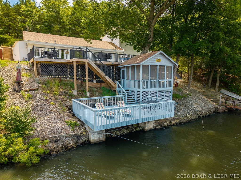 If you've been searching for a lake home where the view truly steals the show, this is it. Enjoy breathtaking, panoramic main channel views while benefiting from the protection of a quiet cove with deep, year-round water - giving you the best of both worlds. Designed for making the most of lake life, the property offers approximately 1,600 square feet of outdoor living space, including low-maintenance decking, a lakeside martini deck perched over the water, and a detached screened-in patio. Whether you're hosting friends, gathering with family, or simply enjoying your morning coffee or an evening cocktail, there is no shortage of places to soak in the incredible view. Inside, the home features 4 bedrooms and 2 full bathrooms, providing comfortable space for family and guests. Ample indoor and outdoor storage makes it easy to keep all of your lake gear organized, from water toys to fishing equipment. With unforgettable views, exceptional outdoor entertaining spaces, and the rare combination of main channel scenery with cove protection, this property offers the lake lifestyle you've been dreaming of. Come see it for yourself!