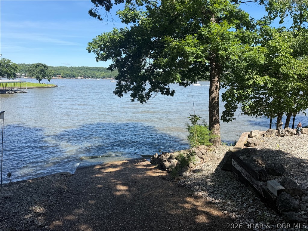 Rare as Hens teeth, this almost 100 ft of moderate shoreline includes a private exposed aggregate concrete boat ramp! Launch your pleasure boat, tritoon, fishing boat or PWC's right in your very own backyard! This lot offers a spectacular view of the main channel yet is protected by a nearby point. Hardscaped with mature trees and located on a private paved road with little vehicular traffic. Packaged with this lot is a second tier lot directly behind lakefront lot that includes a 2 car garage! Located on the 24MM in Osage Beach a short distance to many restaurants including Margaritaville Resort, Paradise Bar & Grill, Redhead Yacht Club, shopping, golfing, airport, and close proximity to the Hospital make this a perfect spot for your new home. The Midwest Coast is calling for you! Note: the previous home was lost due to a fire in spring of 2026 foundation is still in place but has no value.