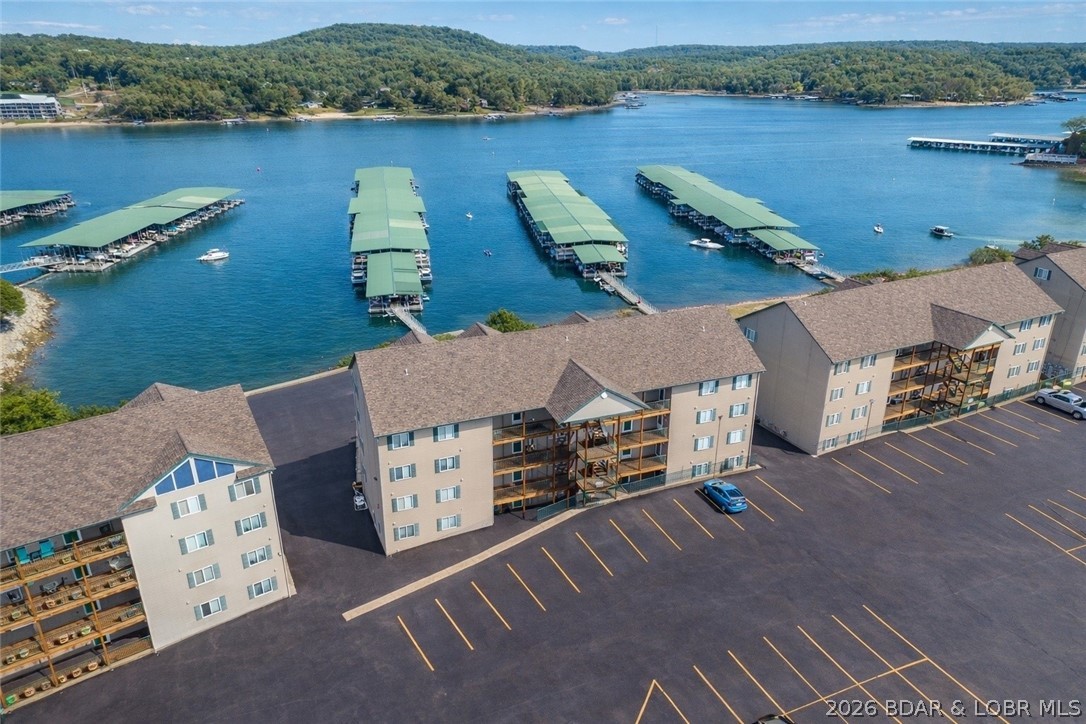 Top-floor 3-bedroom loft condo offering over 1,400 square feet in the highly sought-after Cedar Glen condos at the Lake of the Ozarks. This amenity-rich complex features some of the most level lakefront on the Big Niangua 13MM, along with two heated pools, boat ramp, trailer parking, playground, and sand volleyball court—providing something for everyone. This unit is being sold fully furnished and showcases numerous recent updates, including fresh interior paint, luxury vinyl plank flooring, updated glass shower doors, and newer appliances such as the refrigerator, microwave, washer, and dishwasher. Vaulted ceilings create a spacious, open feel that lives more like a home than a condo. The main level includes a lakeside primary suite with deck access, a second guest bedroom, full guest bath, and an updated kitchen featuring granite countertops. The open-concept living and dining area is anchored by a gas fireplace, ideal for entertaining. The upper-level loft serves as both a third bedroom and second living area. A 10x24 boat slip on Dock 3, located directly in front of the unit, is included. Conveniently located just minutes from Camdenton, Lake Valley Golf, and Old Kinderhook.