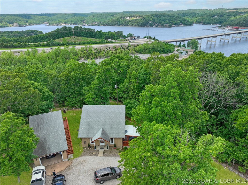 Here's a new listing at 107 View Dr. in the Niangua View Subdivision of Camdenton. This well-maintained home on a gentle one-third acre lot offers a quiet atmosphere and a seasonal lake view, located just five minutes from a boat launch!  The main floor features a comfortable living room with vaulted ceilings and wood floors, a large eat-in kitchen, and a primary bedroom with extensive built-ins and easy access to the laundry and a bathroom with a new flooring and a walk-in shower. Pantry storage under the stairs is also a plus.  Upstairs, you will find a loft bedroom and a large full bathroom.  Bonus Space: A 16x18 heated and cooled room above the garage, perfect for a third bedroom, office, or game room.
- Garage & Storage: A heated and cooled 1+ garage with a workshop area, plus a separate storage shed with stylish barn doors.
- Outdoor Living: A covered deck and a newer wood-fenced yard, ideal for children or pets.
 New septic laterals and the seller has done several things like new water heater, new anti-freeze exterior faucets, new carpet.  Its ready for you to enjoy! 
The subdivision has a community dock.  Seller is checking to see if any slips would be available.