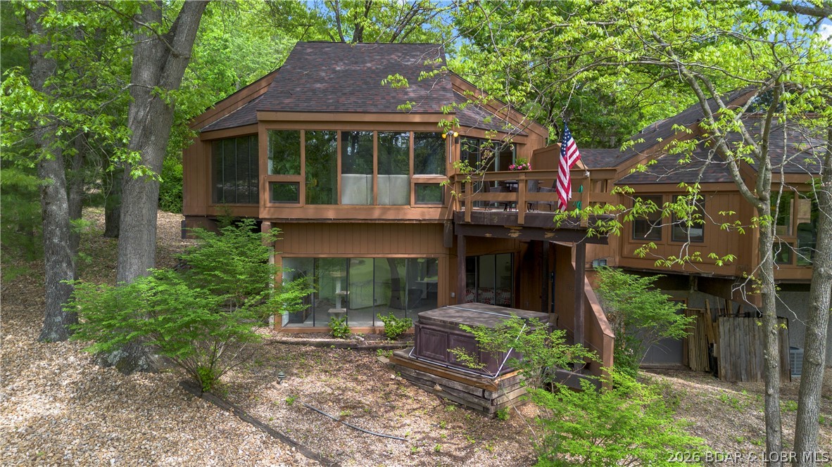 This beautifully furnished Chalet villa is tucked among mature trees and overlooks the 15th fairway of the Four Seasons Cove Golf Course, offering privacy with a scenic backdrop. The light filled interior features an abundance of windows that highlight the villa’s architectural character and warm wood accents. The open main level is ideal for gathering, with a thoughtfully updated kitchen featuring stainless steel appliances, tile backsplash, granite countertops with a marble bar, and a newly added Culligan water softener and kitchen water filtration system with a 15 year warranty. A bright and versatile loft with its own skylight provides the perfect space to relax or unwind. The primary bedroom, surrounded by walls of windows, feels like a modern treehouse retreat. The lower level walkout opens to a private hot tub overlooking the golf course and offers flexible space for a family room, guest area, or additional bedroom. Updates in the last year include new flooring, carpet, interior paint, vanities, fixtures, main level shower, HVAC, and a new roof in 2023. Conveniently located near golf, dining, shopping, and a marina, this home offers comfort, style, and easy lake living.