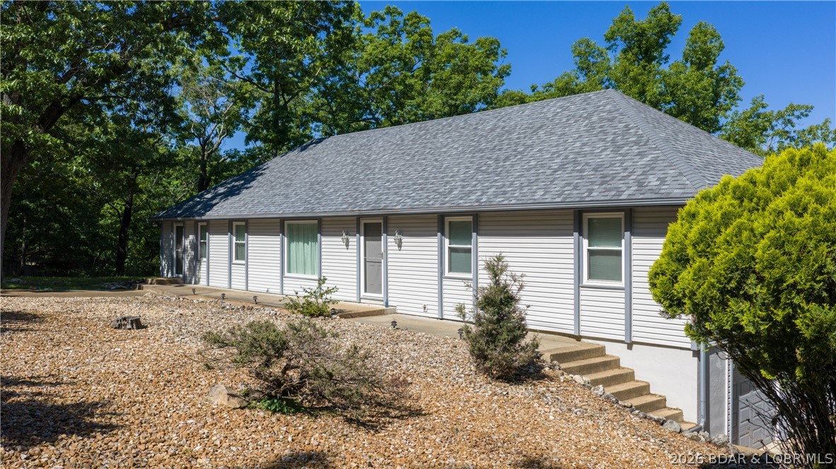 WELL MAINTAINED & ROOMY! Contract fell through, no fault of seller, on this 5 bedroom, 3 bath lake access Osage Beach home. There is community dock & boat ramp and a boat slip is available to rent! Main level has everything you need, vaulted, beamed ceilings & gas fireplace in the living room, large kitchen w/ island & pantry wall and laundry room just off the kitchen for convenience & extra storage. Additionally there is a dining room, office & bonus room (currently music room). 3 bedrooms complete the main level including, main suite w/ attached bath, 2 more bedrooms & full hall bath. Downstairs you find a family room w/ wet bar, 2 additional bedrooms w/ Jack & Jill bath, gigantic storage/craft room & oversized two car garage. Plenty of outdoor living with a screened porch on main level & the partially covered patio on the lower level. Just off the patio is rock outcropping that would make an awesome firepit area. Just down the driveway & across Cherry Blossom you'll find the community swim/fishing dock.  A new roof was installed in 2025. Golf, elementary school, hospital, restaurants & shopping are close by. This home is being sold partially furnished and rentals are allowed.