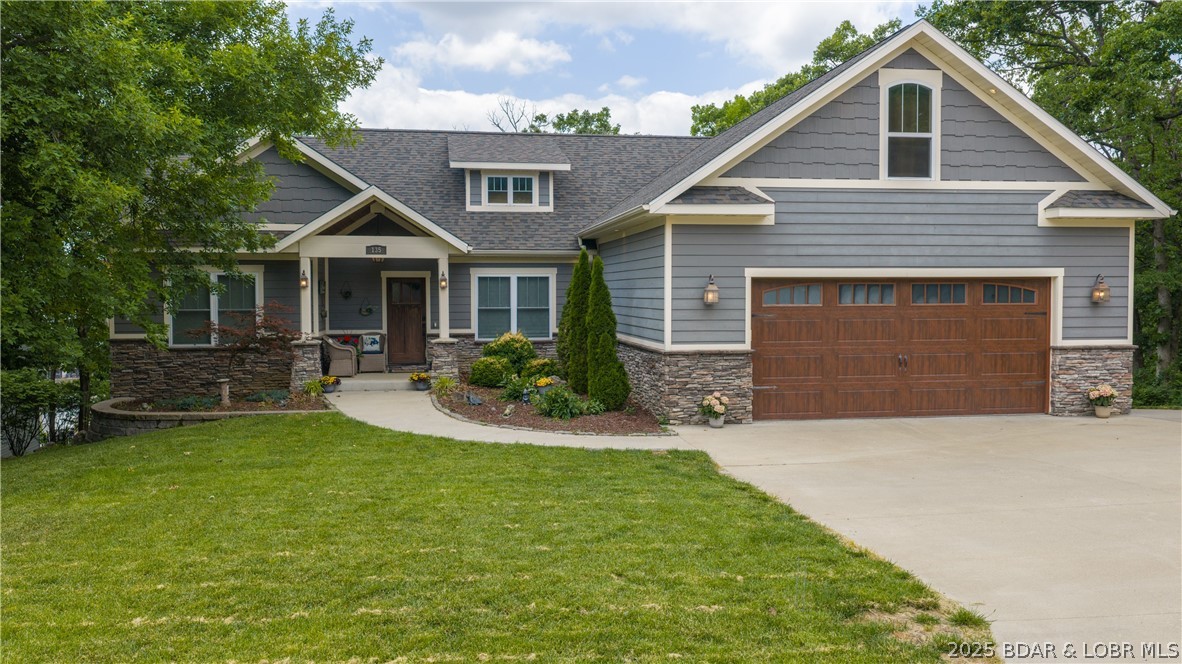 Brand new roof installed May 2026 and a new price that is hard to beat!  This custom Craftsman home is priced at just $163/sq ft - well below todays replacement cost. Enjoy peace of mind knowing this big-ticket update has been completed. This stunning, home offers nearly 4400 sq ft of luxurious living space, featuring 6 generously sized bedrooms, an open & alluring floor plan, & exceptional storage throughout. From the inviting screened-in-deck to the cozy two-way fireplace this home welcomes you w/ well-designed, intentional details. Distressed hardwood floors add timeless character & warmth to the main living areas.  A 3rd lower-level garage space has many possibilities like storage, workshop, fitness or hobbies. A rare luxury is the flat yard & driveway w/ ample parking. Even better this property includes a 12x32 boat slip, giving you instant access to lake living. All of this in a prime location just minutes from grocery stores, popular restaurants, schools, churches & the iconic Bagnell Dam.  The Estates also has a private pool to soak up the sun & socialize w/ your neighbors. If you have been searching for value, quality, & equity then 135 Windjammer delivers!