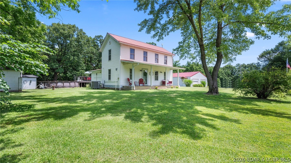 Absolutely charming cottage-core farmhouse situated on small acreage just outside of town, offering privacy, character, and a beautiful country setting. This thoughtfully updated and meticulously maintained home is full of warmth and charm, featuring 3 bedrooms, 2 bathrooms, and convenient main-level laundry. The main level is inviting and functional, highlighted by an adorable kitchen that perfectly complements the home's farmhouse character. Cozy living spaces and thoughtful updates throughout create a warm, welcoming feel. Upstairs, a loft-style second living area provides flexible space for a family room, office, reading nook, or play area. Outside, you'll find a beautiful flat yard with room to enjoy the peaceful surroundings. Relax by the pool, entertain guests, or simply take in the picturesque setting. The detached 2-car garage offers much more than parking space, featuring a half bath, workshop area, and an additional finished space ideal for hobbies, gatherings, or guest overflow. PLUS, 50 Amp electric for an RV! Offering exceptional privacy while remaining conveniently located just outside of town, this is a special property that feels like home the moment you arrive.