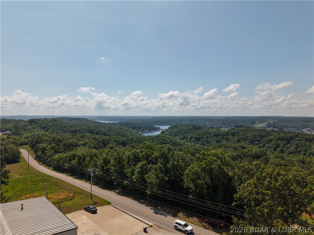 Discover the possibilities with this 6.8-acre wooded tract in Twin Rivers Point near Greenview. Offering nearly 1,200 feet of paved road frontage, this property provides exceptional access and countless opportunities for future use. Whether you're looking for land to build, a recreational retreat, a long-term investment, or simply a place to enjoy everything the Lake of the Ozarks has to offer, this property is ready for your vision. The rolling wooded terrain features a seasonal lake view and shared community lake access, allowing you to enjoy the water without the cost of waterfront ownership. Conveniently located near marinas, restaurants, golf courses, and outdoor recreation, this tract offers the ideal combination of accessibility and versatility. Large parcels with this much paved road frontage and community lake access are becoming increasingly difficult to find. Seller prefers seller financing terms, creating an excellent opportunity for buyers looking for flexible financing options.