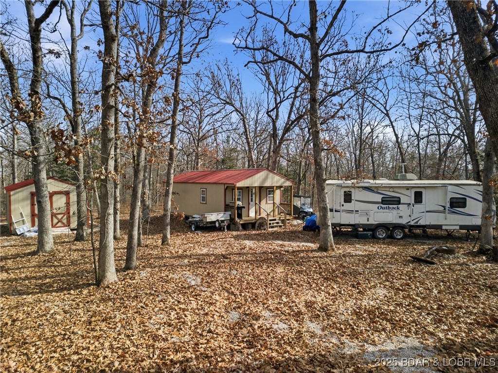Come see this peaceful 18.67 acres with NO RESTRICTIONS. Gentrly rolling, and heavily wooded at the end of Quantrill Hollow Rd, this large parcel is perfect for hunting or your perfect little hobby farm. 16x36 (including front porch) building/cabin already has Anderson flooring installed, is wired and insulated, and waiting for plumbing and connection to the already installed 1000 gallon septic tank. Water is also hooked up to a frost-free hydrant, and easily connected to the cabin which already has walls partitioned off for a small bedroom, bathroom, and living area. Underground electric already on site with the ability to hook up an RV to both power, sewer and water. Second building is 14x24 and a blank slate to be turned into another cabin or simple storage. The slate is blank and ready for you to make it your own. Most of the furniture is there and ready to be set up to start enjoying the property. Mower, trailers, golf cart available for extra money. There's also a path cut along the property line to give you easy access to the back of the property. Take a look at this great hunting retreat or forever home in a private, buatiful setting. Less than 20 minutes to Camdenton!