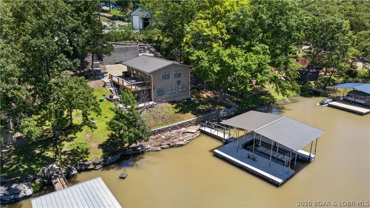 Lake life is all about spending your days on the water & your evenings enjoying everything the Lake of the Ozarks has to offer—and this beautifully remodeled home at the 80 Mile Marker puts you right in the middle of it all- also a peaceful place to relax when the day is done. This extensively updated 2-bedroom, 1.5-bath home offers the low-maintenance lake lifestyle you've been searching for. Recent renovations include new flooring, fresh paint, and a completely updated kitchen w/new cabinetry, creating a move-in-ready retreat that's designed for enjoying the lake rather than working on projects. Inside, the spacious living area showcases beautiful lake views & provides plenty of room for gathering with family & friends. Step outside to the large deck & covered patio where you can entertain, grill, or simply enjoy watching boats pass by. The property also features abundant concrete parking on two levels, making it easy to accommodate guests on busy lake weekends. The dock sits in good water and provides quick access to endless days of boating, fishing, swimming, and exploring the lake.