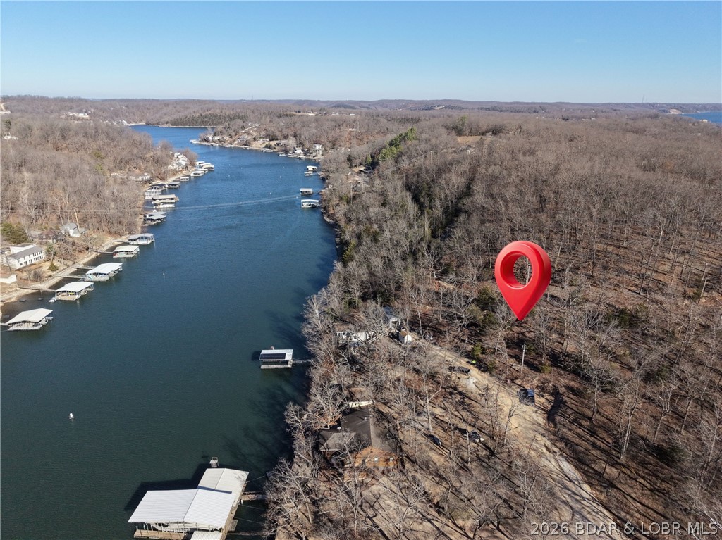 Create your own Lake of the Ozarks retreat on this peaceful, wooded parcel off Harvest Road. Enjoy lake views and a private Ozark setting while remaining close to everyday conveniences—approximately 10 minutes from Camdenton and just 5 minutes from State Highway 5. With electric available from a pole at the property, this land offers an inviting opportunity for a cabin, tiny home, weekend getaway, or future investment. Imagine a cozy retreat surrounded by trees, where mornings begin with water views and evenings feel removed from the crowds. If you’ve been looking for an affordable place to build near the lake without giving up convenient access to shopping, dining, and recreation, this property deserves a closer look. Bring your plans and explore the possibilities!