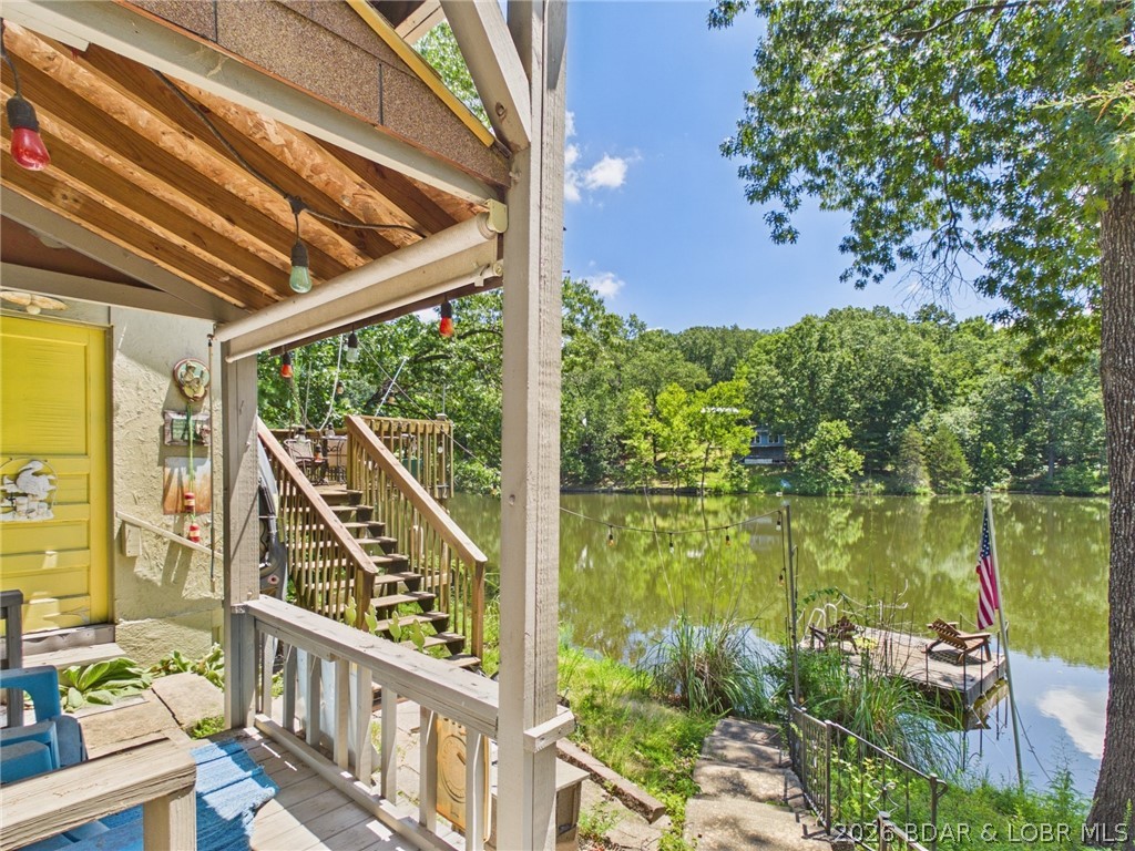 Rare waterfront opportunity on a private interior fishing lake just minutes from Lake of the Ozarks! Enjoy the best of both worlds with peaceful lakefront living and Patriot Point Marina less than 2 miles away for easy access to boating, dining, & recreation on the Lake of the Ozarks. This inviting home with community water and a BRAND NEW ROOF features a bright, open main level with beautiful water views, creating the perfect setting for everyday living or weekend escapes. Step outside onto the multiple deck areas and enjoy your own 75' of waterfront, ideal for great fishing, swimming, relaxing, entertaining, or simply enjoying the tranquil surroundings. The lower level offers a private entrance, half bath, storage area, and a versatile and cozy living/bedroom area (no closet), making it an excellent option for guests, a hobby room, home office, or potential rental space. Another large locking storage area helps keep track of the lake toys. Whether you're searching for an STR investment opportunity, full-time residence, or vacation retreat, this unique property offers flexibility, peaceful surroundings, and an unbeatable location near all the amenities of Lake of the Ozarks.